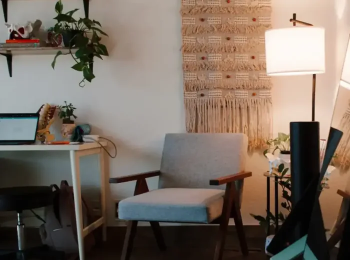 Clinic office corner with armchair, macrame hanging and warm floor lamp
