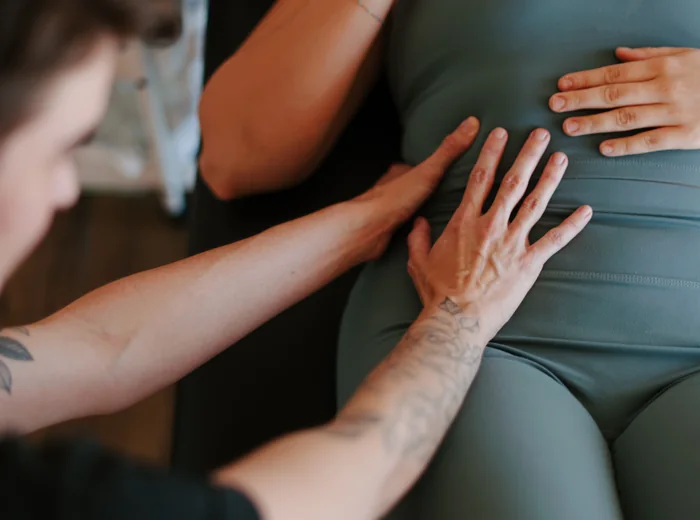 Dr. Hare's hands resting flat on a patient's abdomen during assessment